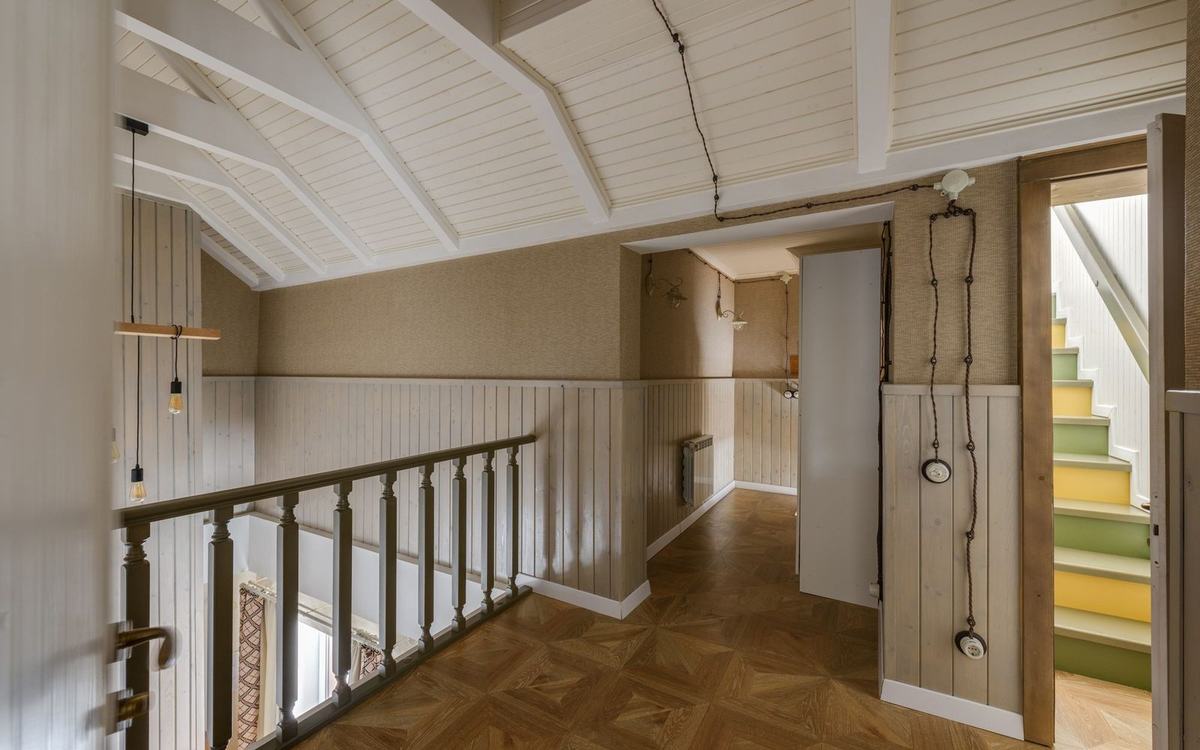 Timber panelled landing with painted balustrade and staircase beyond